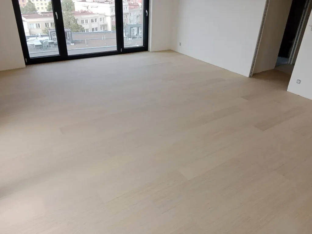 Světlá dřevěná podlaha v bytě s výhledem na Prahu